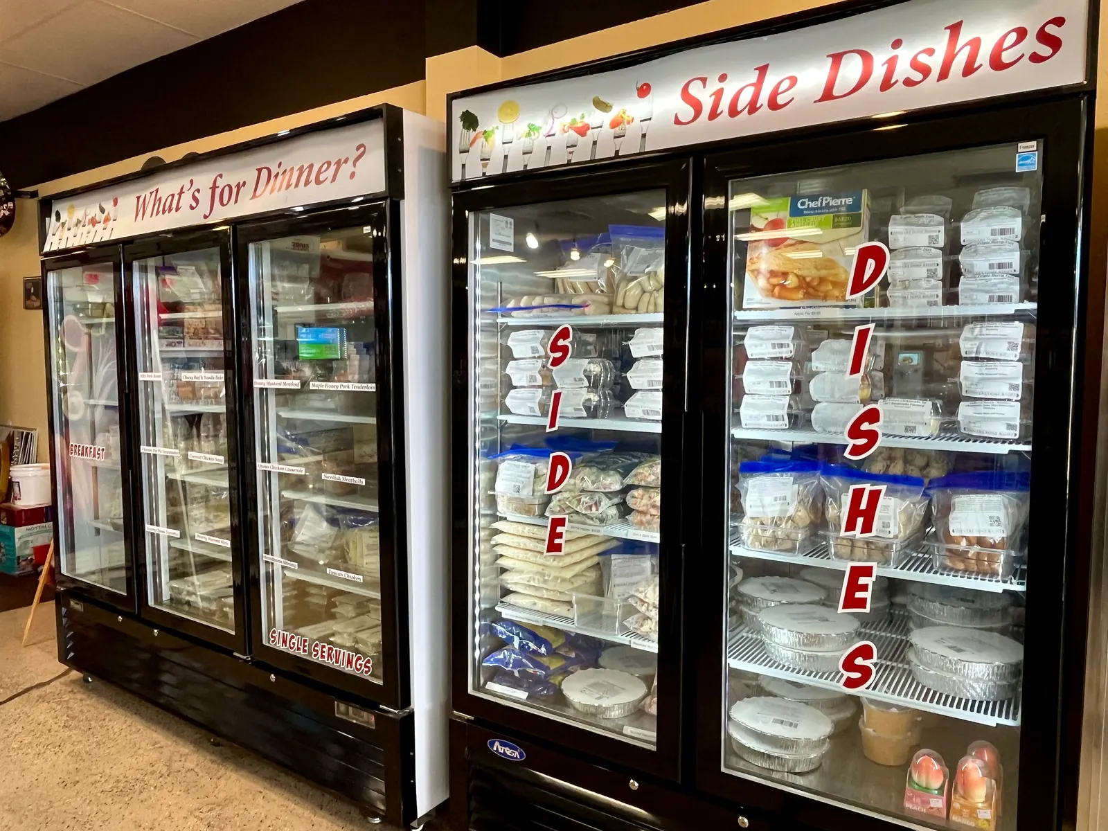 Freezer cases stocked with prepared take-home meals at Dinners Done Right